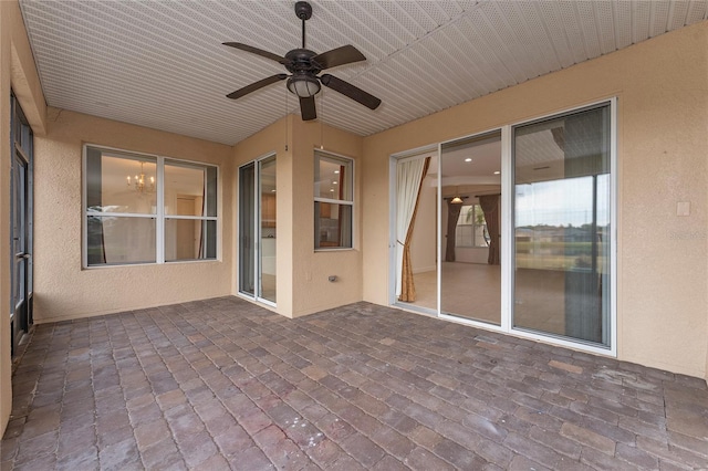 unfurnished sunroom with ceiling fan