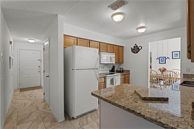 kitchen with sink, white appliances, light stone countertops, a textured ceiling, and kitchen peninsula