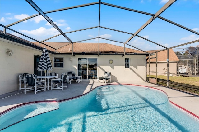 view of swimming pool featuring a patio area and glass enclosure