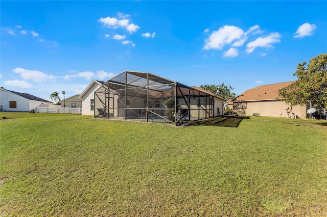 rear view of property featuring glass enclosure and a lawn