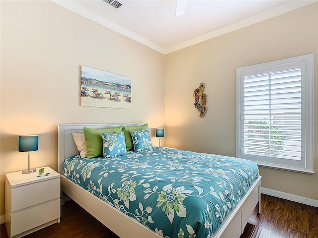 bedroom featuring ornamental molding and dark hardwood / wood-style floors