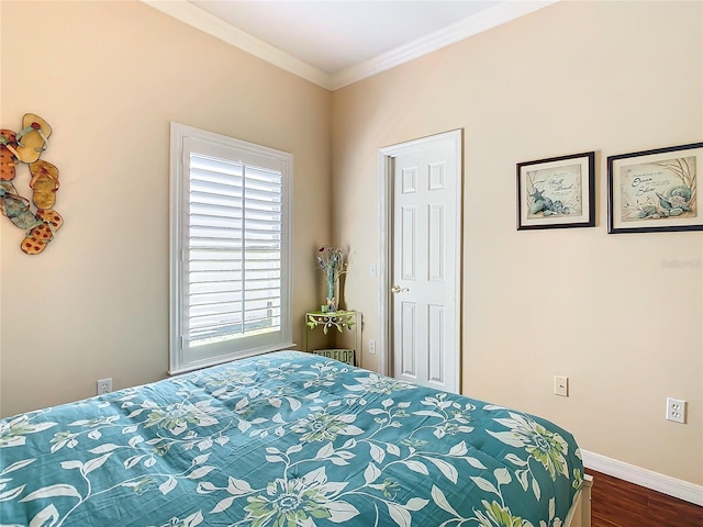 bedroom with ornamental molding and dark hardwood / wood-style floors