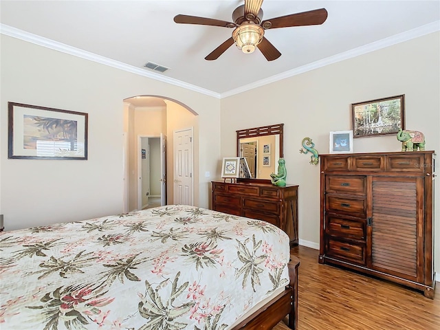 bedroom with crown molding, light hardwood / wood-style flooring, and ceiling fan