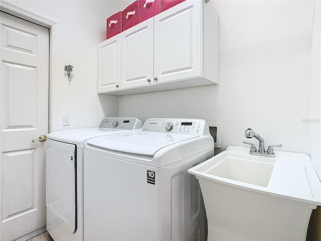 laundry room with cabinets, washing machine and dryer, and sink