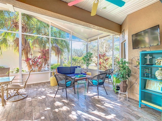 sunroom featuring lofted ceiling with beams and ceiling fan