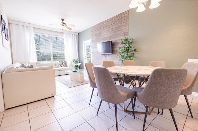 tiled dining space with ceiling fan with notable chandelier