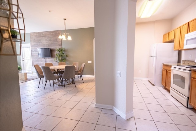 kitchen with white appliances, decorative light fixtures, a notable chandelier, and light tile patterned floors