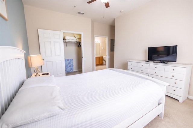 carpeted bedroom with ensuite bath, a walk in closet, a closet, and ceiling fan