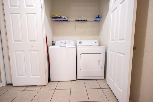 laundry room featuring separate washer and dryer and light tile patterned floors