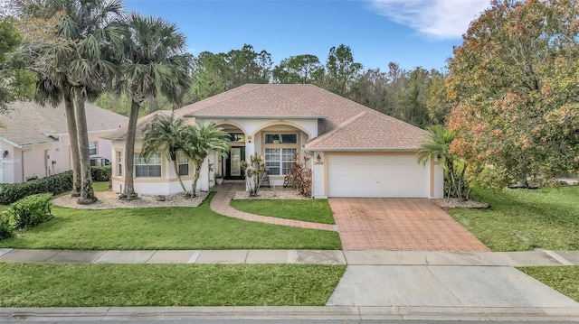 mediterranean / spanish-style house featuring a garage and a front yard