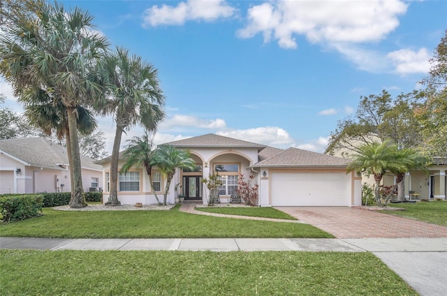 mediterranean / spanish house featuring a garage and a front yard