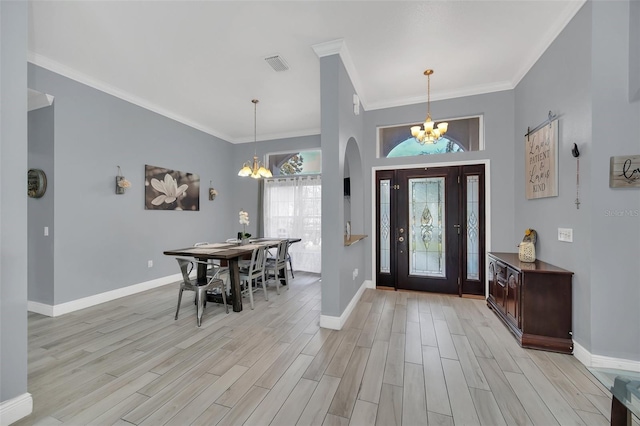 entrance foyer featuring crown molding, light wood-type flooring, and a chandelier