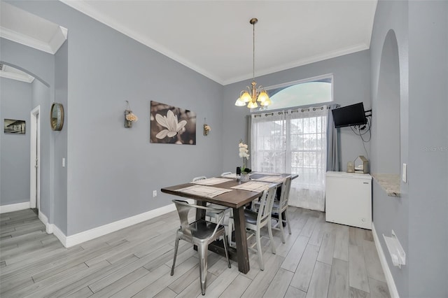 dining room featuring crown molding, a chandelier, and light hardwood / wood-style flooring