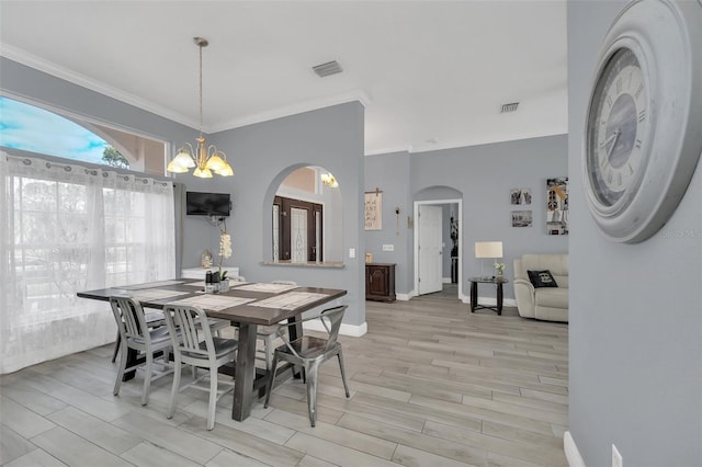 dining area with a notable chandelier and crown molding