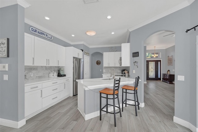 kitchen with white cabinetry, a breakfast bar area, crown molding, and decorative backsplash