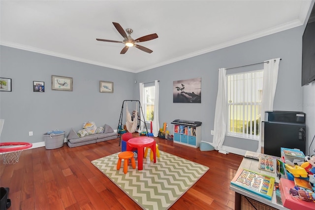 rec room with crown molding, ceiling fan, and wood-type flooring