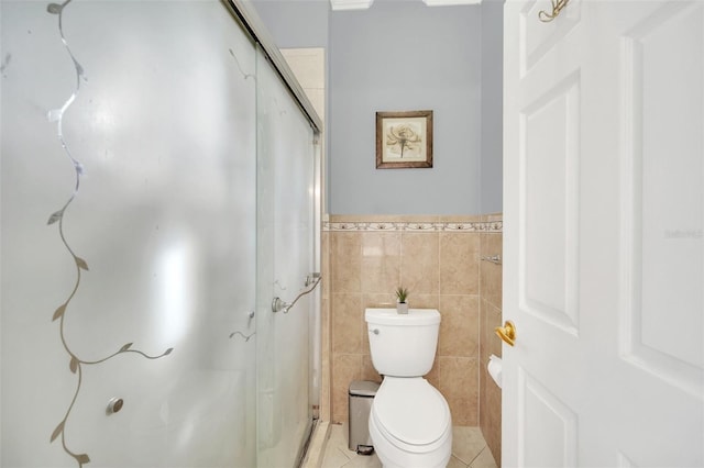 bathroom with tile walls, tile patterned flooring, a shower with shower door, and toilet