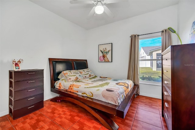 tiled bedroom featuring ceiling fan