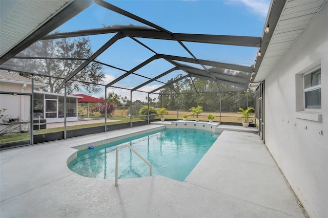 view of pool with glass enclosure and a patio area