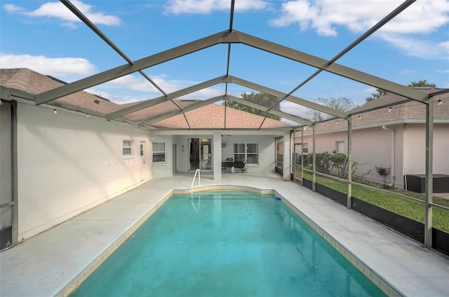 view of swimming pool featuring a lanai and a patio area