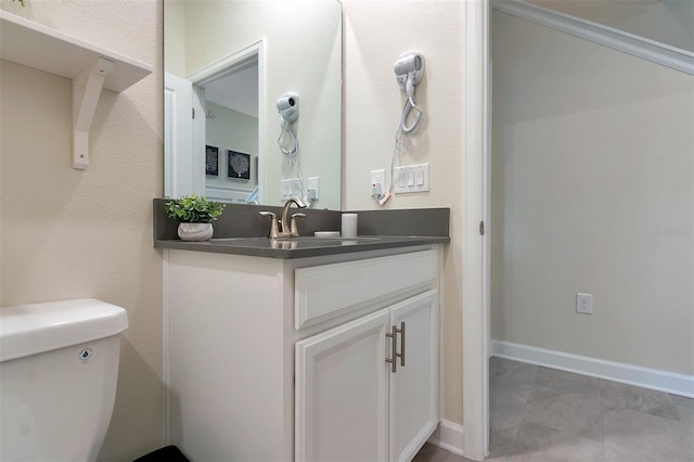 bathroom featuring vanity, tile patterned floors, and toilet