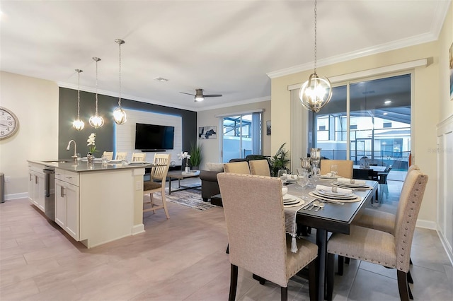 dining space featuring ceiling fan, ornamental molding, and sink