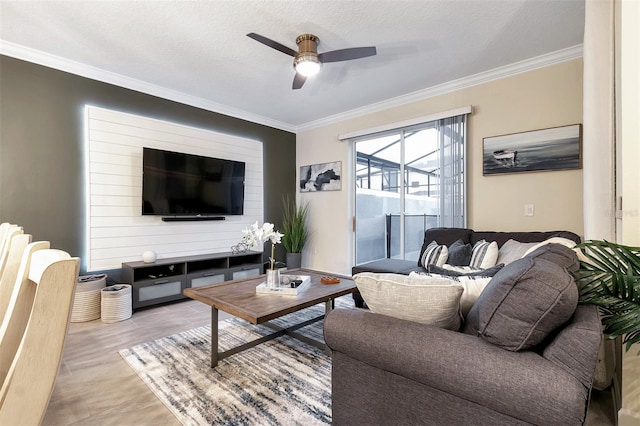 living room with crown molding, light wood-type flooring, a textured ceiling, and ceiling fan