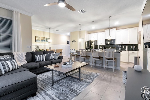 living room with light tile patterned floors, a textured ceiling, and ceiling fan