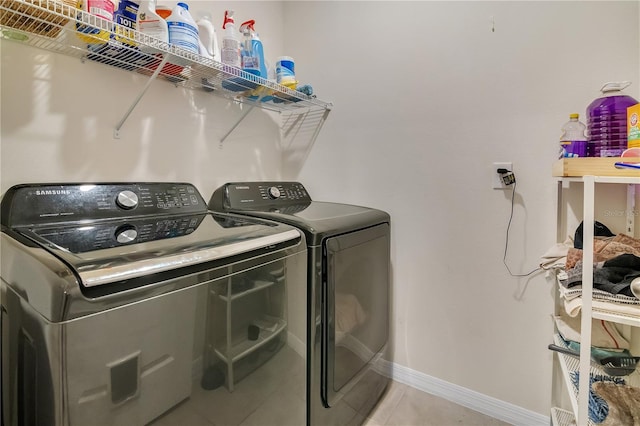 clothes washing area with light tile patterned floors and independent washer and dryer