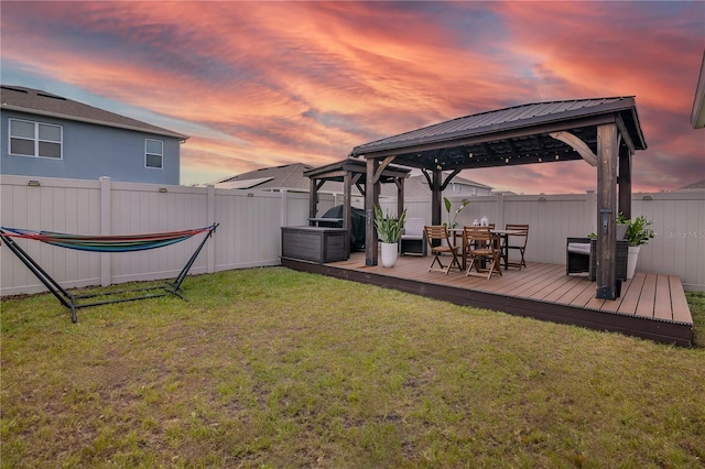 yard at dusk with a gazebo and a wooden deck