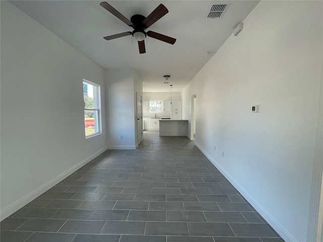 unfurnished room featuring ceiling fan and dark tile patterned floors