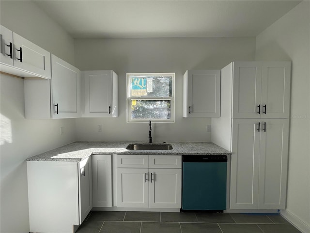 kitchen with sink, dark tile patterned floors, stainless steel dishwasher, and white cabinets