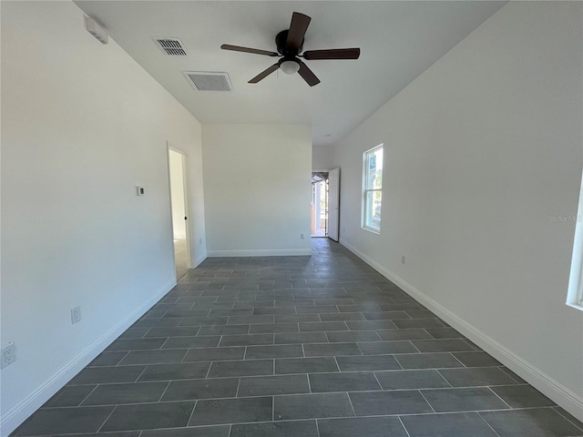 spare room with dark tile patterned floors and ceiling fan