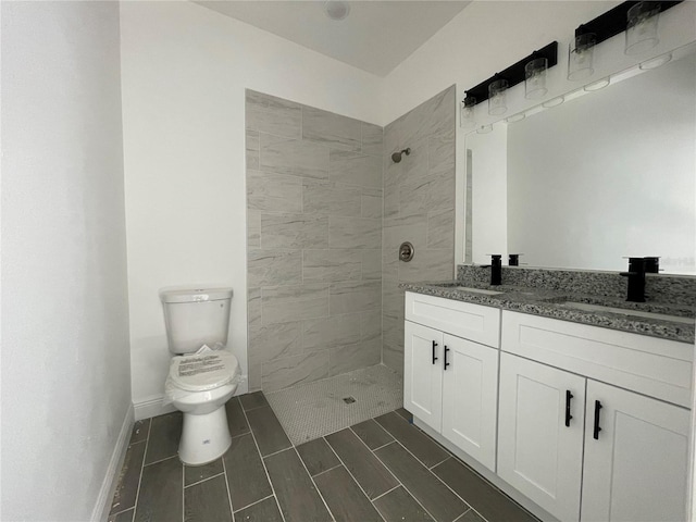 bathroom featuring vanity, toilet, and tiled shower