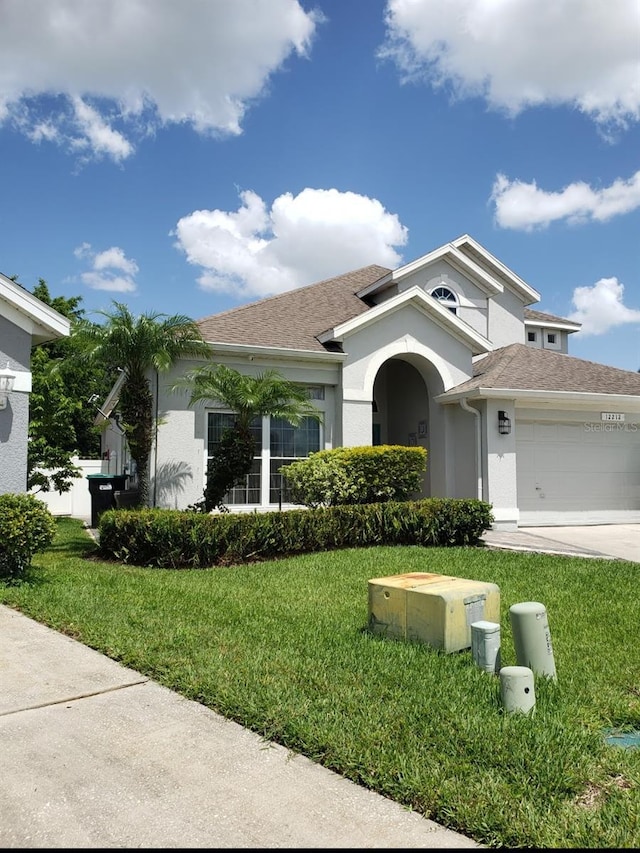 view of front of house featuring a garage and a front lawn