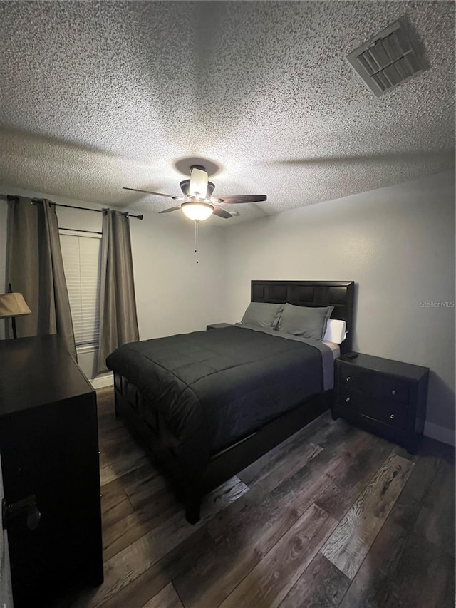 bedroom with dark hardwood / wood-style floors, a textured ceiling, and ceiling fan