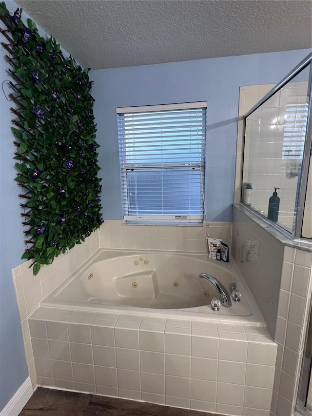 bathroom featuring a textured ceiling and separate shower and tub