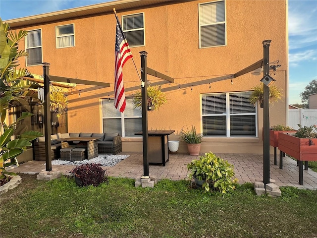 rear view of house with an outdoor hangout area, a patio area, and a lawn