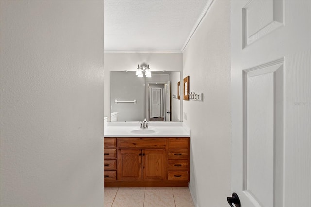 bathroom featuring tile patterned flooring, vanity, ornamental molding, and a textured ceiling