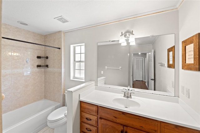 full bathroom featuring tiled shower / bath combo, vanity, and toilet