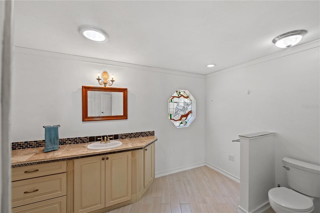 bathroom featuring vanity, crown molding, toilet, and hardwood / wood-style flooring