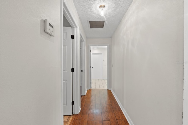 hallway featuring hardwood / wood-style flooring and a textured ceiling