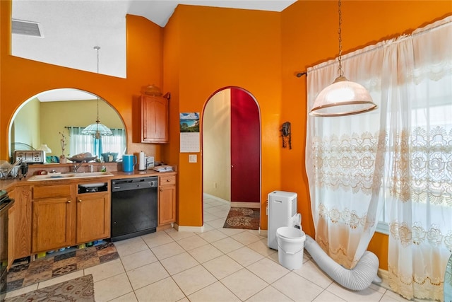 kitchen featuring light tile patterned flooring, black dishwasher, sink, and decorative light fixtures