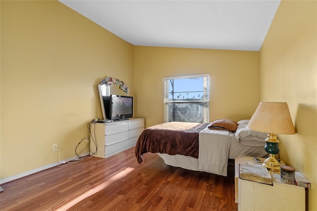 bedroom featuring lofted ceiling and hardwood / wood-style floors