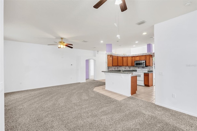 kitchen with a kitchen island, white electric range oven, light carpet, and ceiling fan