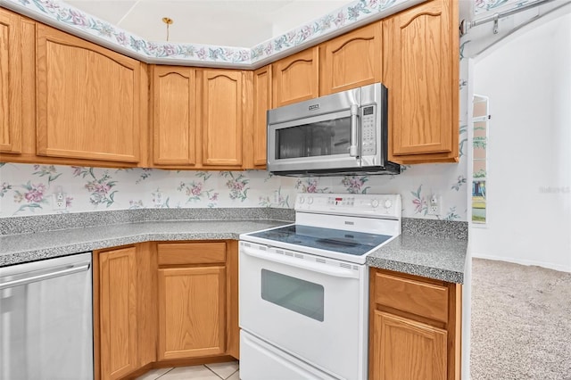 kitchen with light tile patterned floors and stainless steel appliances