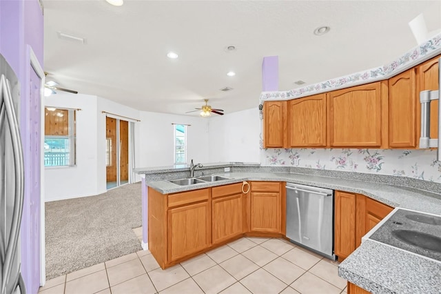 kitchen featuring sink, light carpet, kitchen peninsula, ceiling fan, and stainless steel appliances