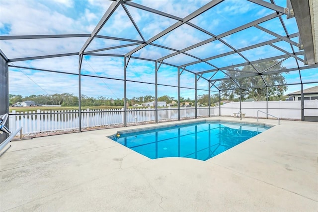 view of pool featuring a patio, a water view, and glass enclosure