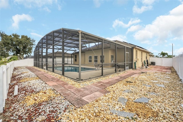 back of house featuring a fenced in pool, a patio, central air condition unit, and glass enclosure