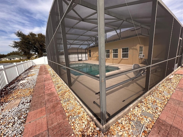 view of pool featuring cooling unit, glass enclosure, and a patio area